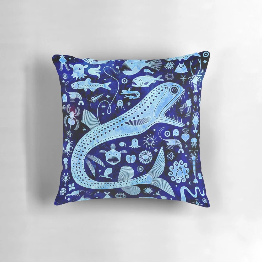 A decorative pillow featuring vibrant illustrations of deep sea creatures like anglerfish, jellyfish, and squid.