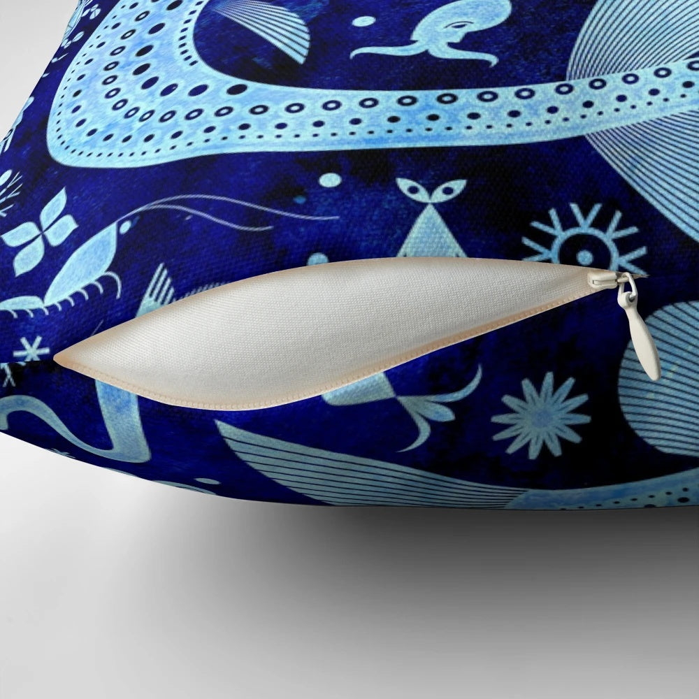 A decorative pillow featuring vibrant illustrations of deep sea creatures like anglerfish, jellyfish, and squid.