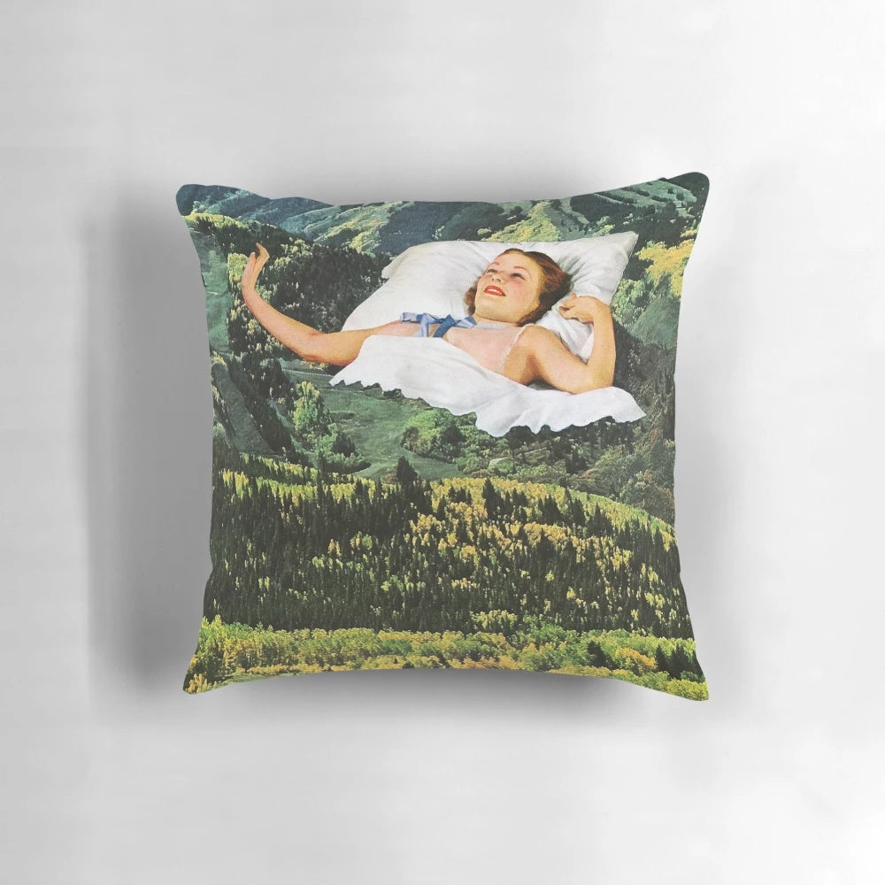 A collage art pillow featuring a surreal, vintage-inspired design of a mountain landscape.
