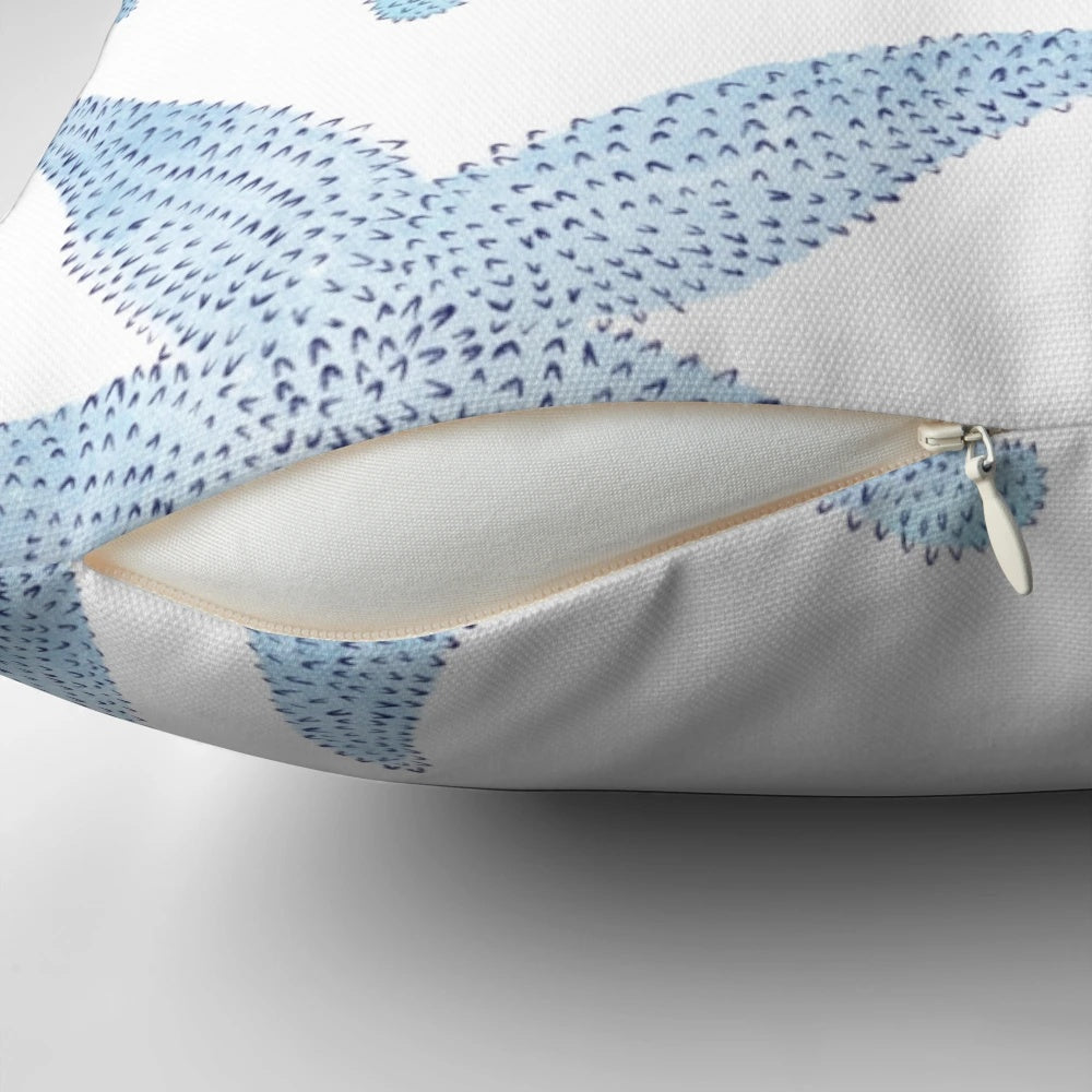 A decorative pillow featuring a vibrant watercolor painting of dancing blue starfish against a soft, white background.