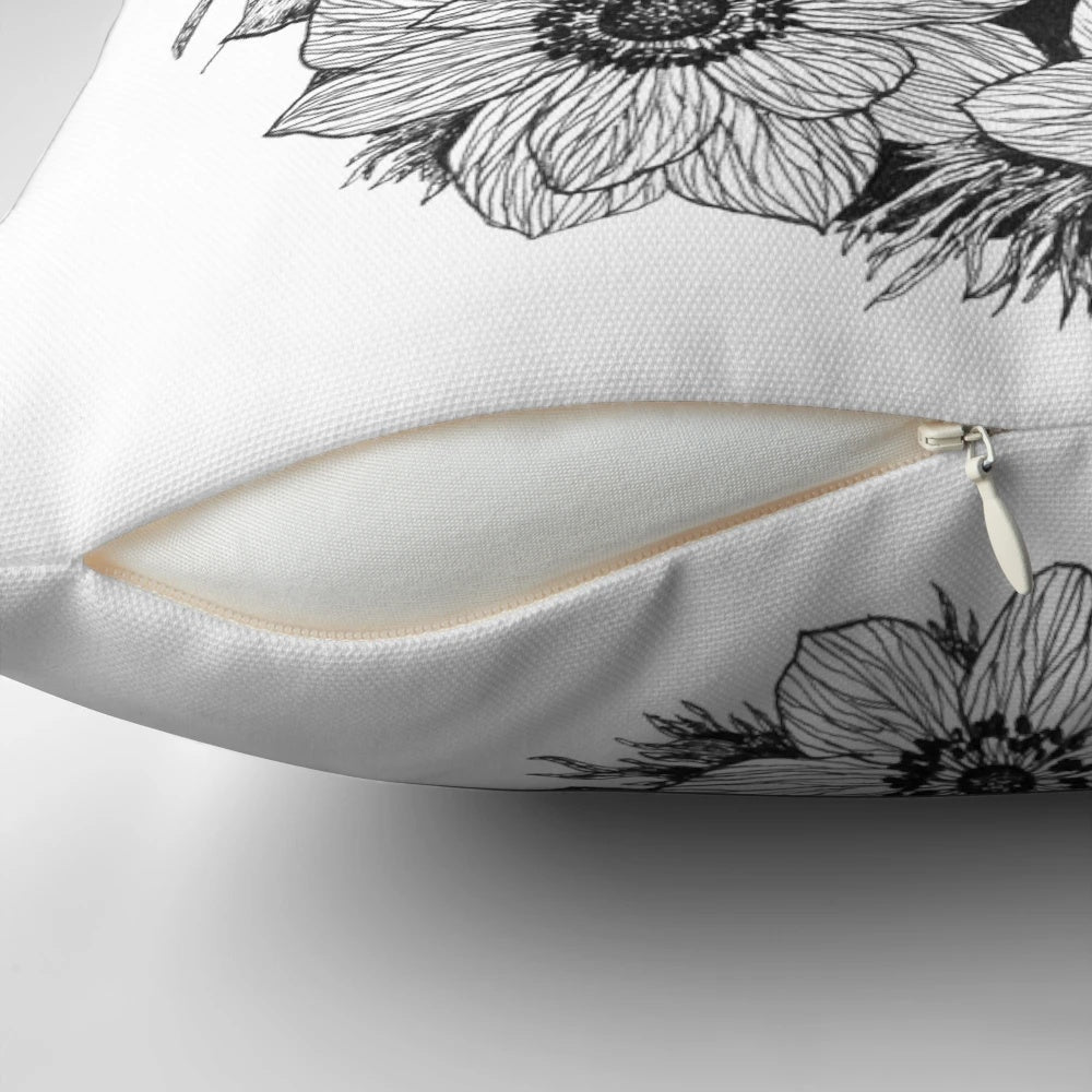 Moody black and white portrait of a woman surrounded by ethereal flowers and butterflies on a decorative pillow