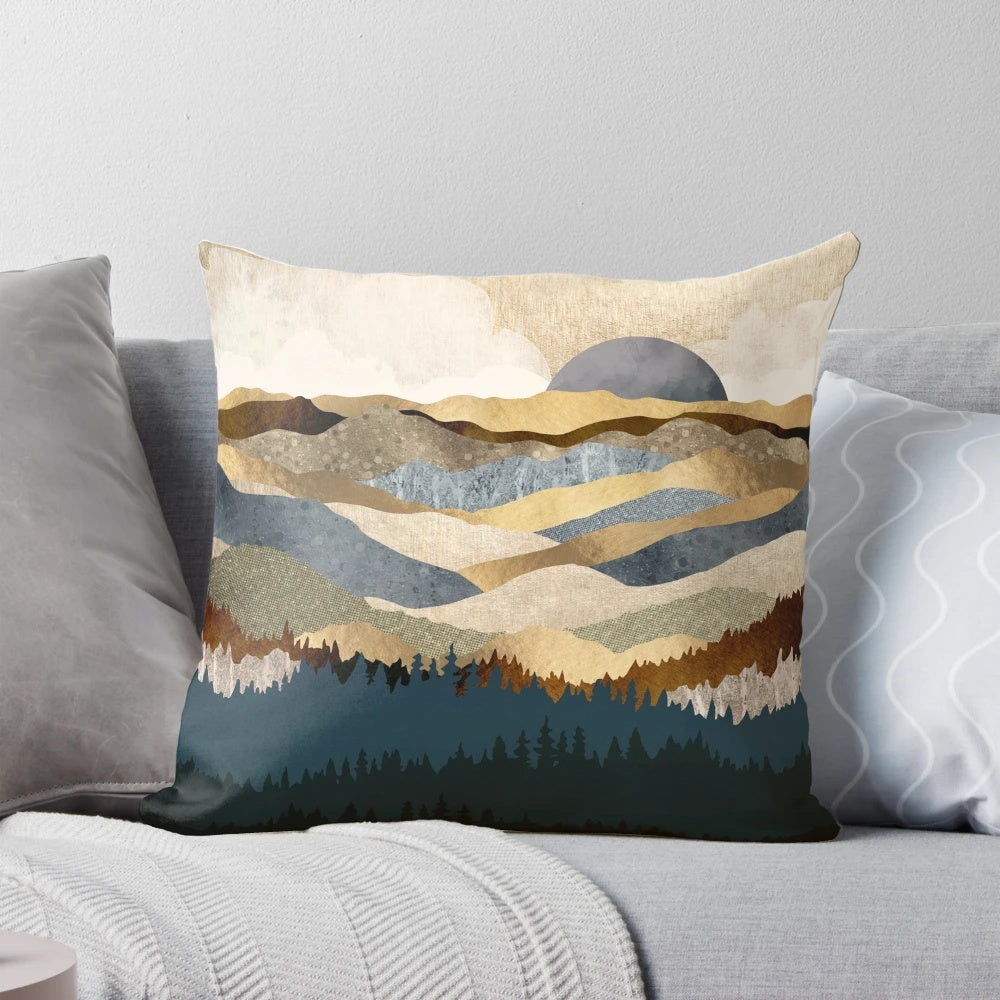 A golden, abstract landscape pillow featuring mountains, trees, and a serene vista.