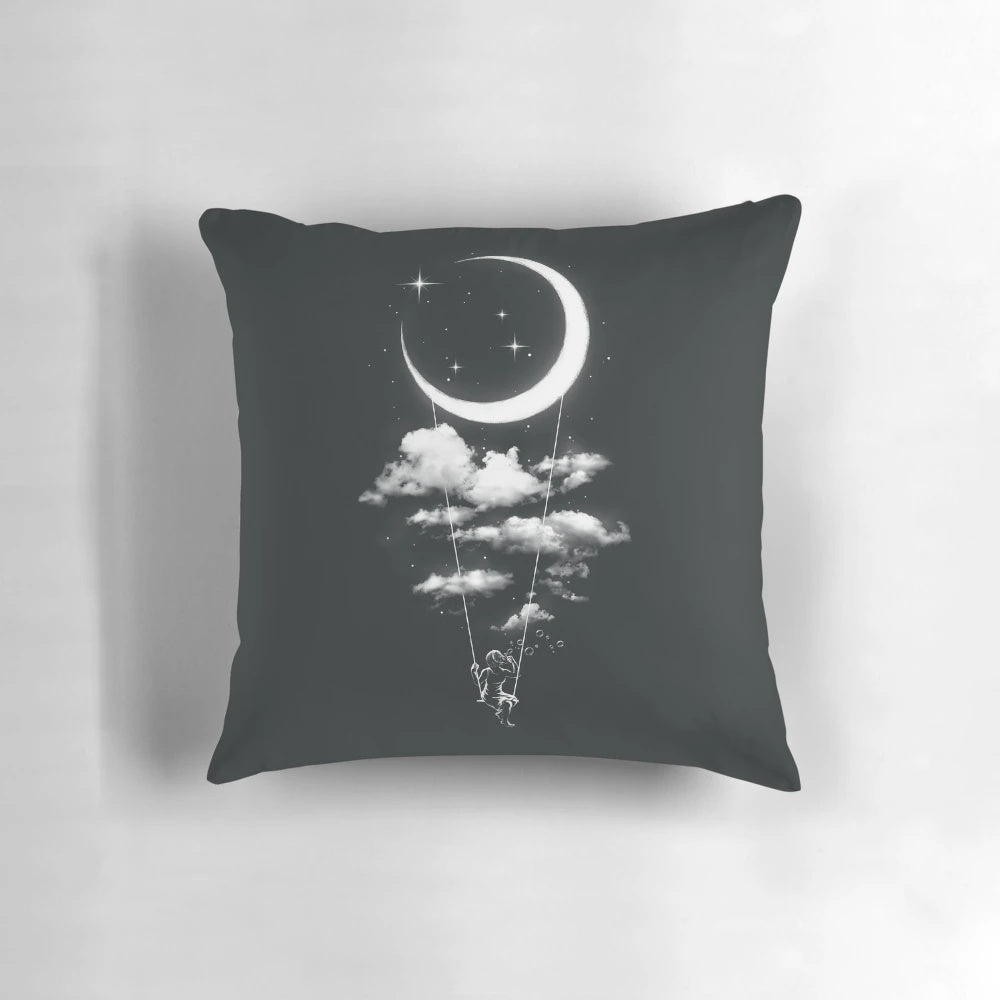 Soft, plush moon-shaped pillow swinging on a metal frame against a starry night sky backdrop