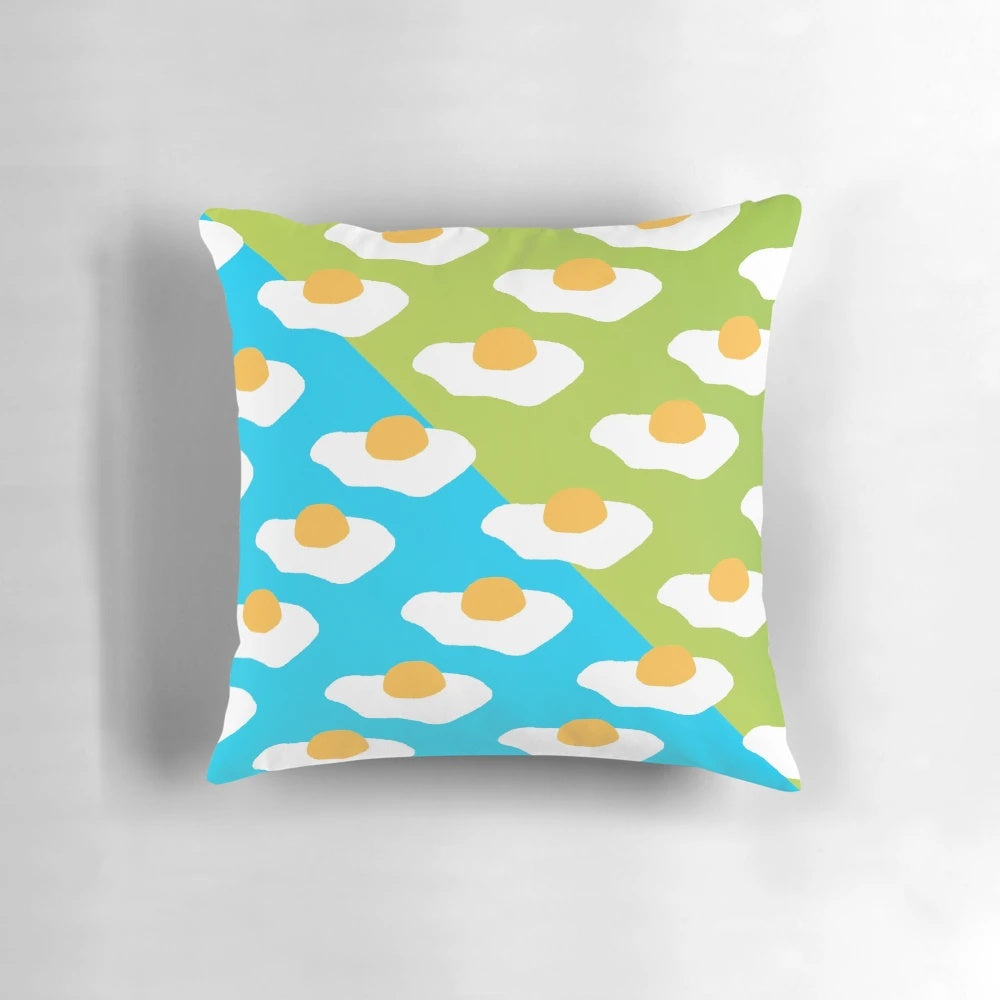 Colorful Eggsellent-themed pillow with a sunny side up egg pattern in blue and green hues