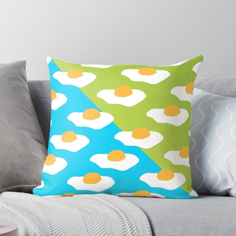Colorful Eggsellent-themed pillow with a sunny side up egg pattern in blue and green hues