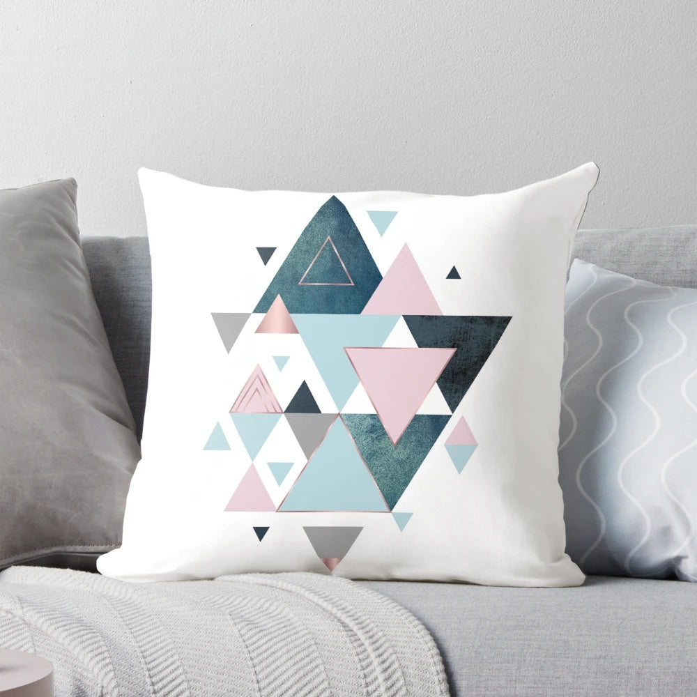Stylish abstract triangle pattern pillow in shades of pink, teal, and blue