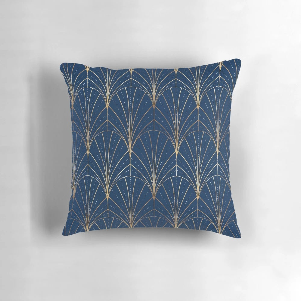 A navy blue decorative pillow with an art deco waterfall pattern in gold and dark colors