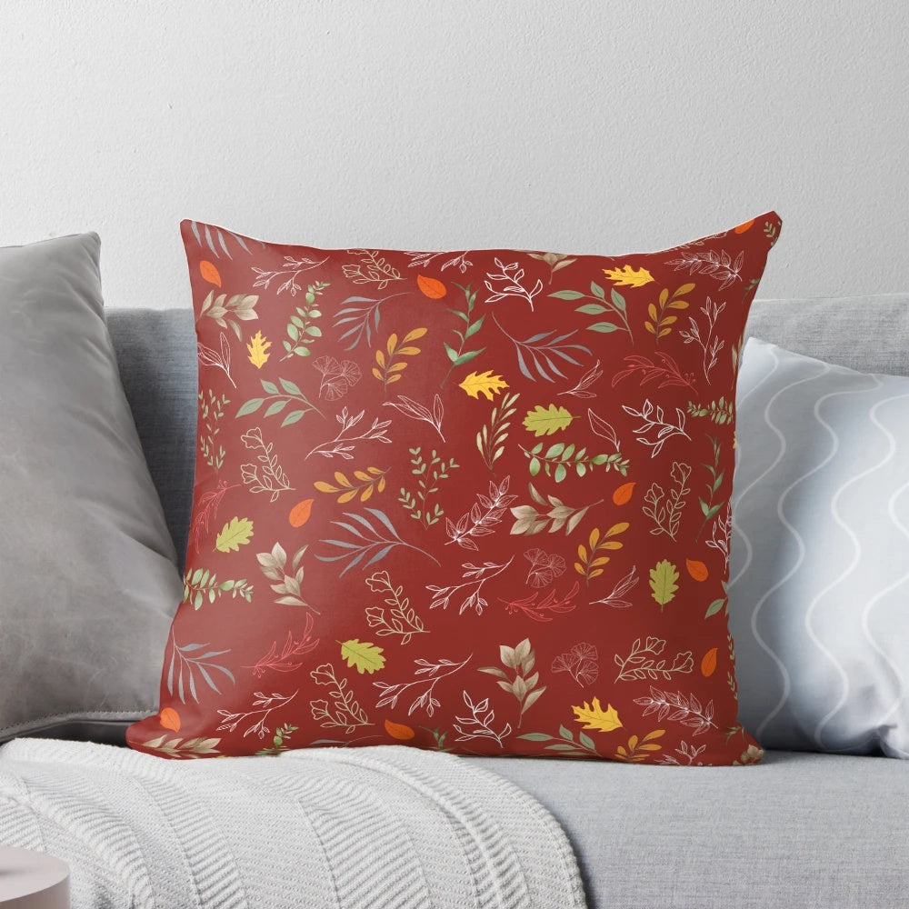 Autumn foliage-inspired throw pillow with red and green leaves on a neutral background