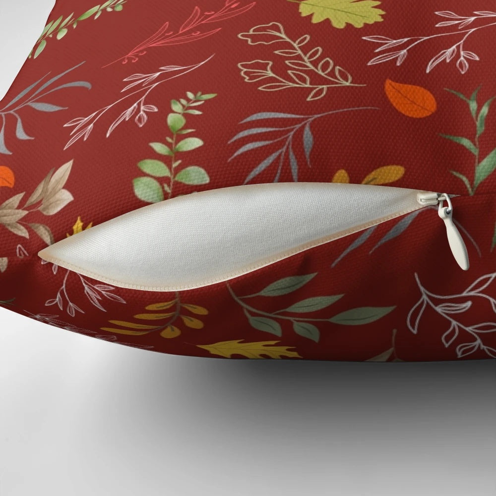 Autumn foliage-inspired throw pillow with red and green leaves on a neutral background