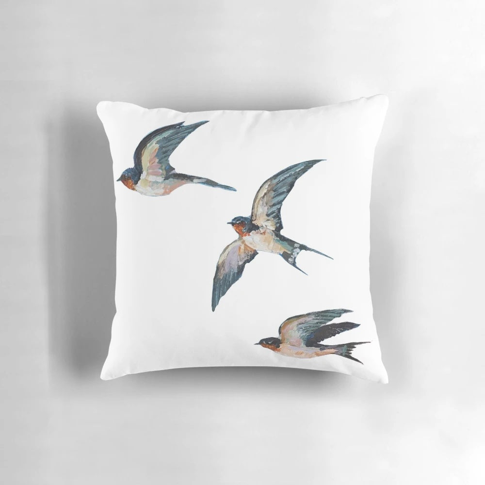 Vibrant acrylic painting of three elegant barn swallows in flight on a decorative throw pillow