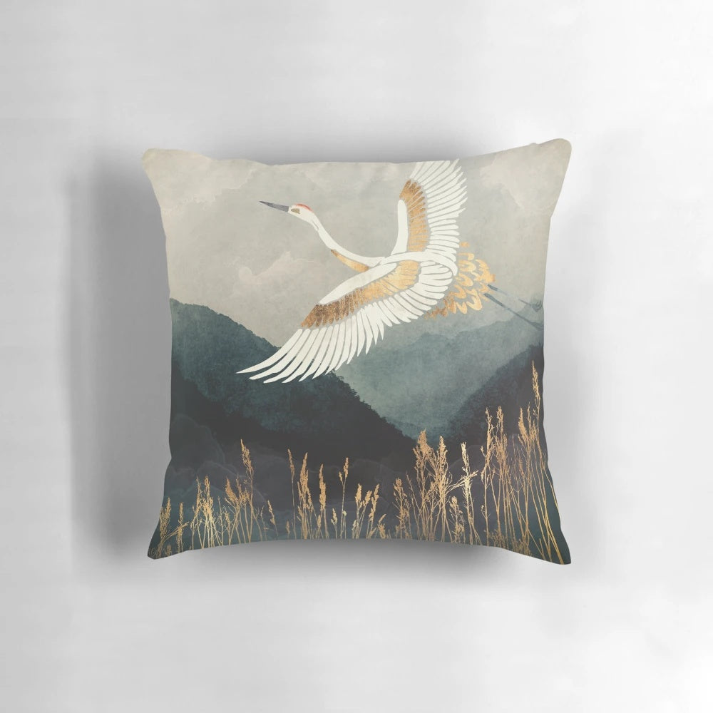 An elegant pillow featuring a watercolor-style design of a flying crane or bird in a nature landscape.