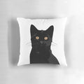 A black cat peeking out from a plush, comfortable pillow
