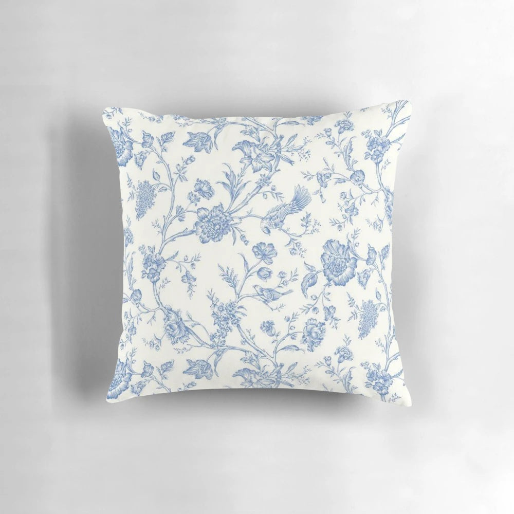 Blue and white toile pillow featuring a bird and nature motif