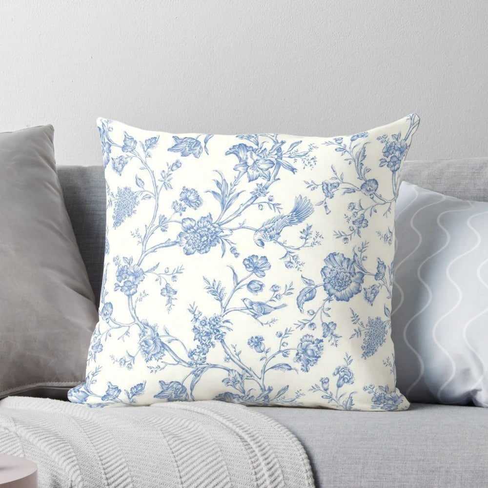 Blue and white toile pillow featuring a bird and nature motif