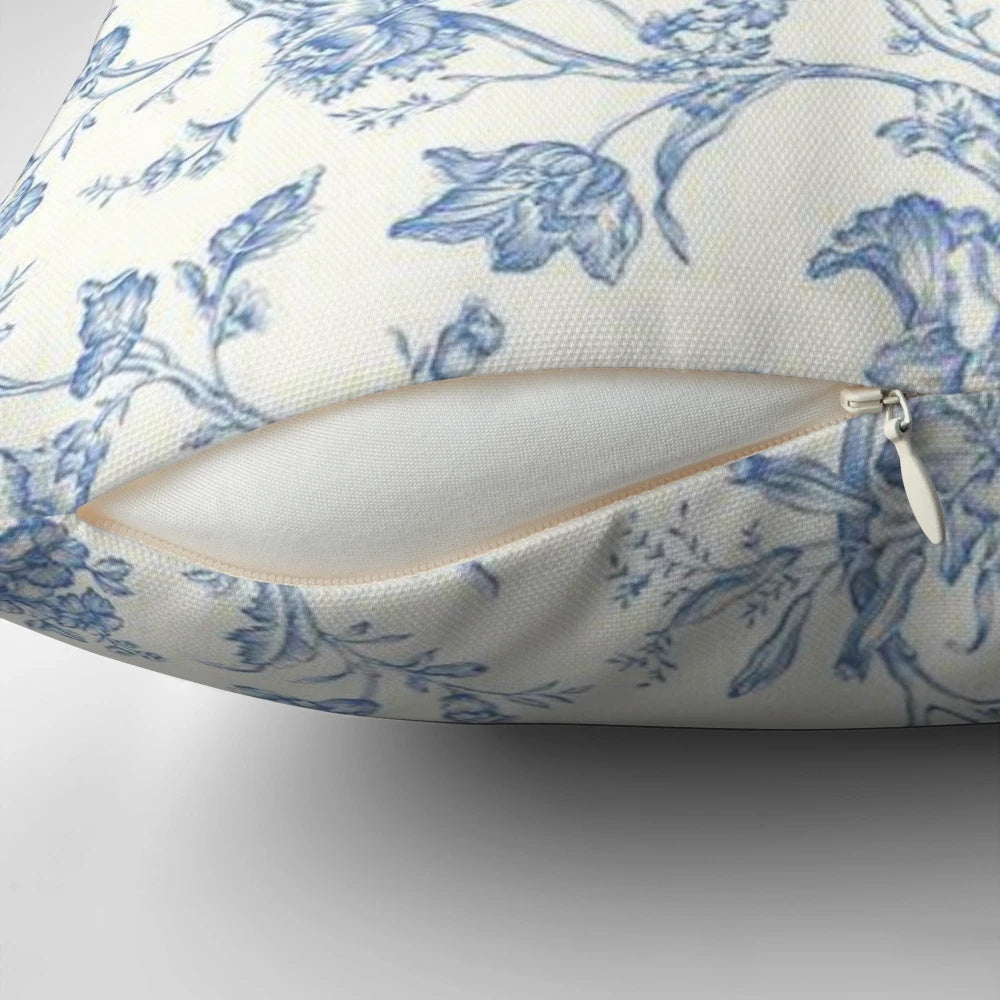 Blue and white toile pillow featuring a bird and nature motif