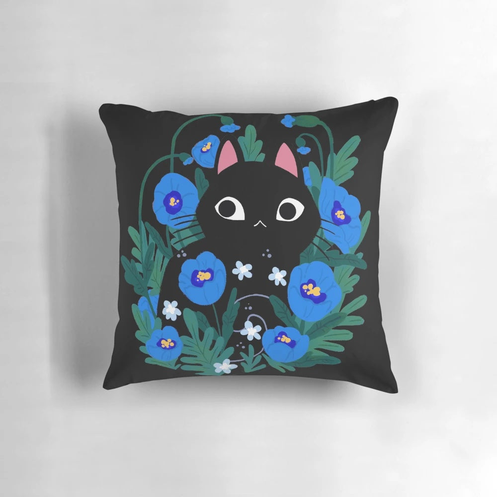 Blue and black throw pillow with an illustration of a black cat surrounded by blue flowers