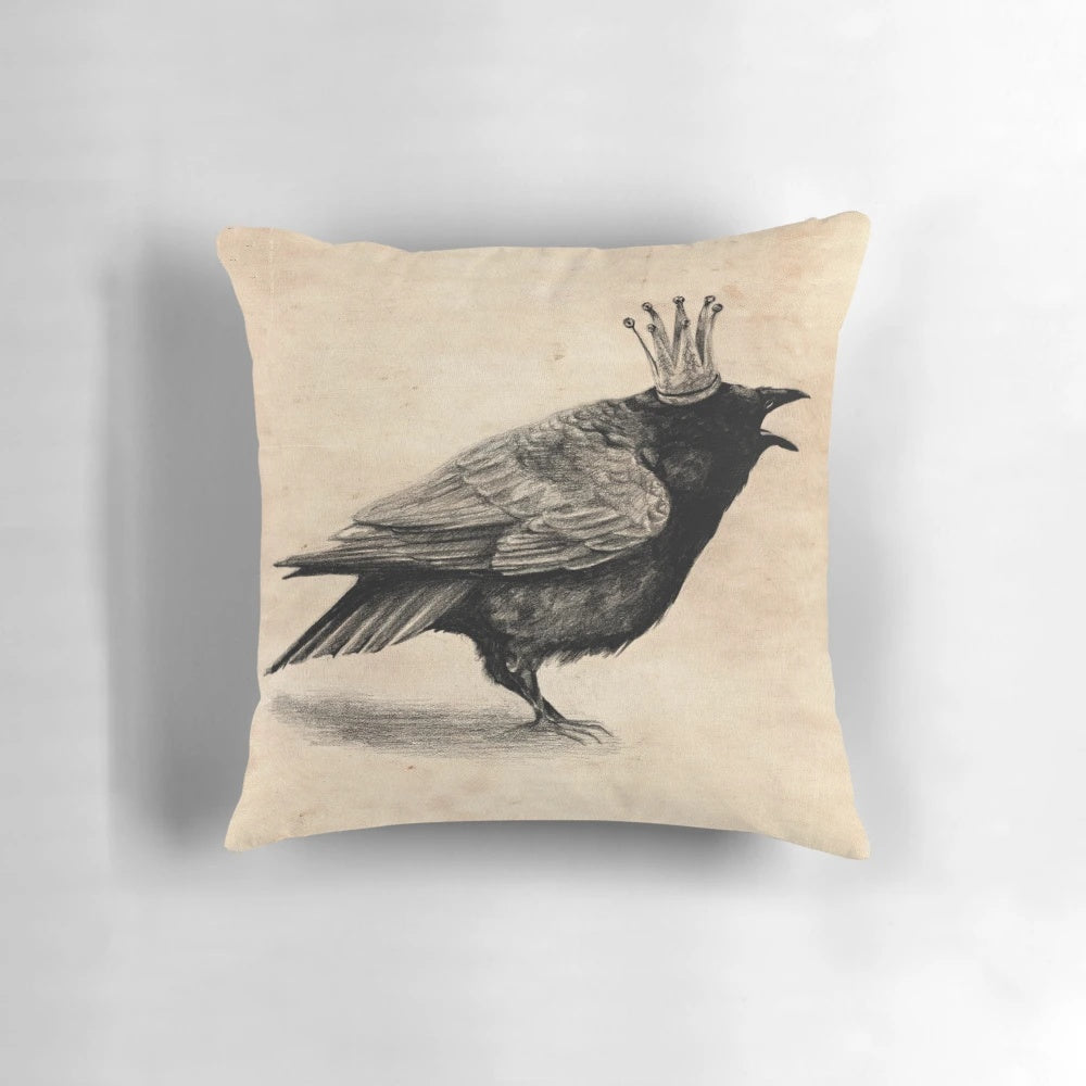 A stylish throw pillow featuring a black and white raven or crow wearing a crown, perfect for adding a touch of whimsy to your home decor.