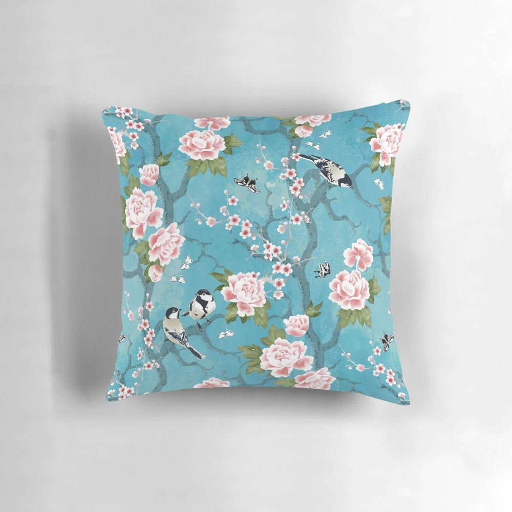 Decorative Chinoiserie-inspired pillow with birds in turquoise blue and floral elements