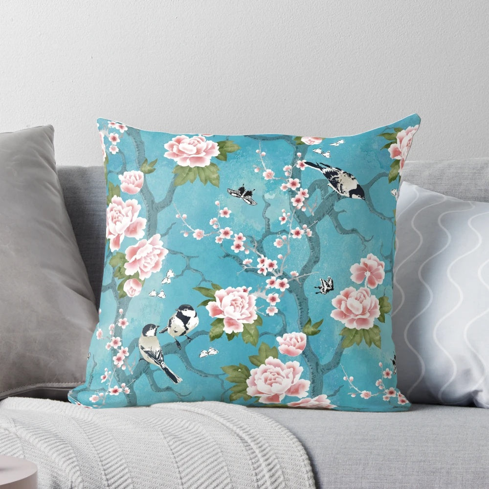 Decorative Chinoiserie-inspired pillow with birds in turquoise blue and floral elements