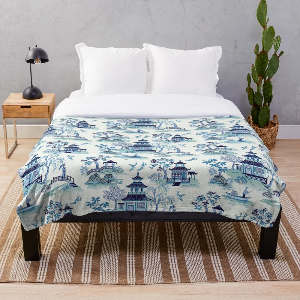 Chinoiserie-style blue plush blanket with pagoda and willow pattern design