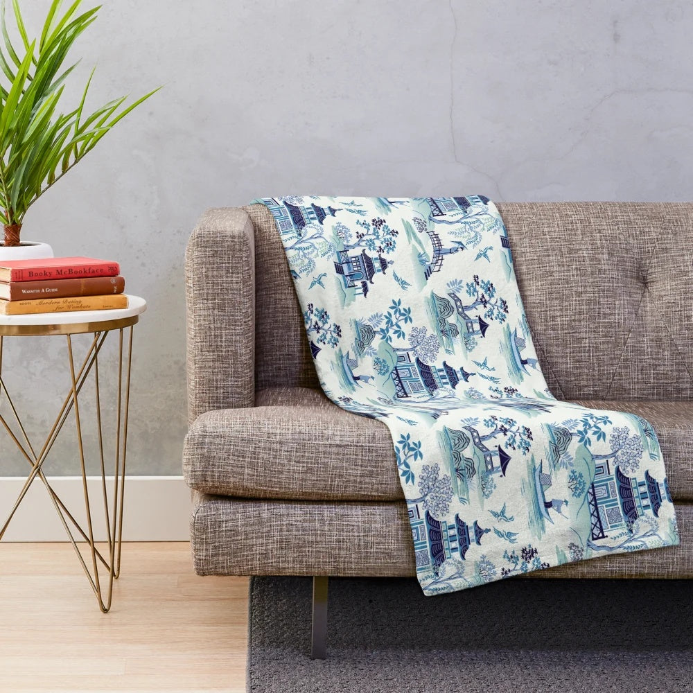 Chinoiserie-style blue plush blanket with pagoda and willow pattern design