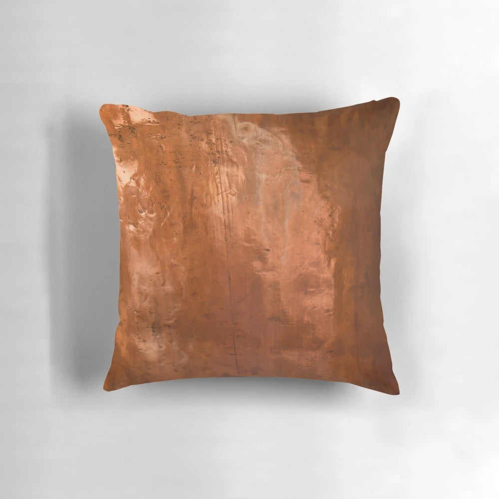 Close-up of a copper metallic pillow with abstract, ray-like design