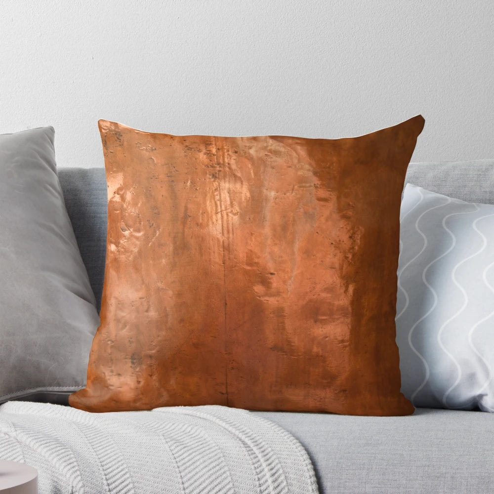 Close-up of a copper metallic pillow with abstract, ray-like design
