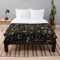 Plush blanket featuring ancient Egyptian hieroglyphic designs in black and gold