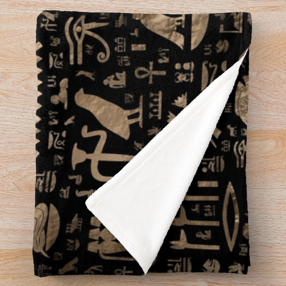 Plush blanket featuring ancient Egyptian hieroglyphic designs in black and gold