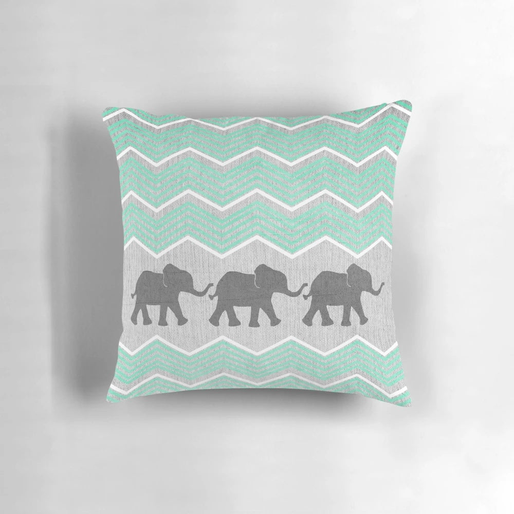 Three stylized elephants in shades of grey, teal, and turquoise on a patterned background.