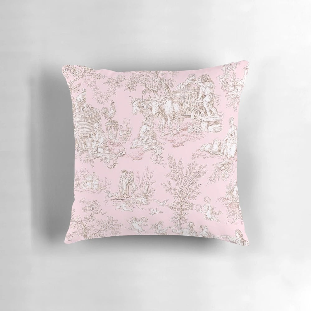 A pink and white toile patterned pillow with a French country design featuring birds and branches.