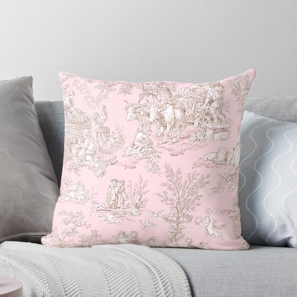 A pink and white toile patterned pillow with a French country design featuring birds and branches.