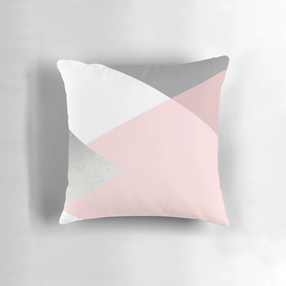 Decorative geometric pattern pillow in shades of grey, blush, and silver