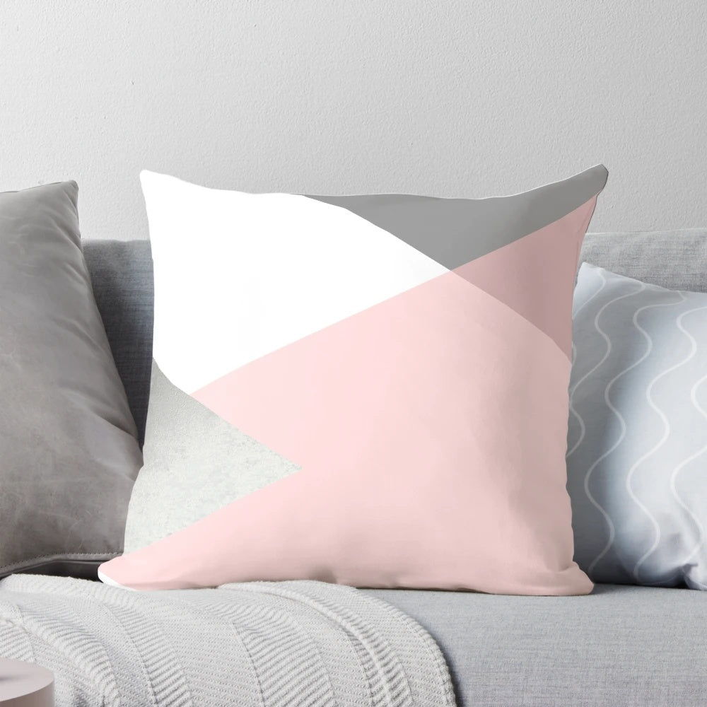 Decorative geometric pattern pillow in shades of grey, blush, and silver