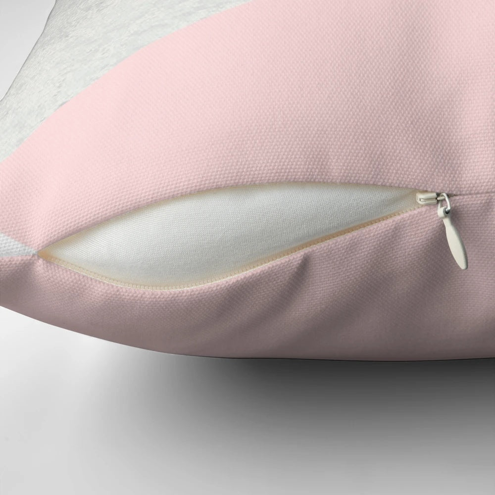 Decorative geometric pattern pillow in shades of grey, blush, and silver