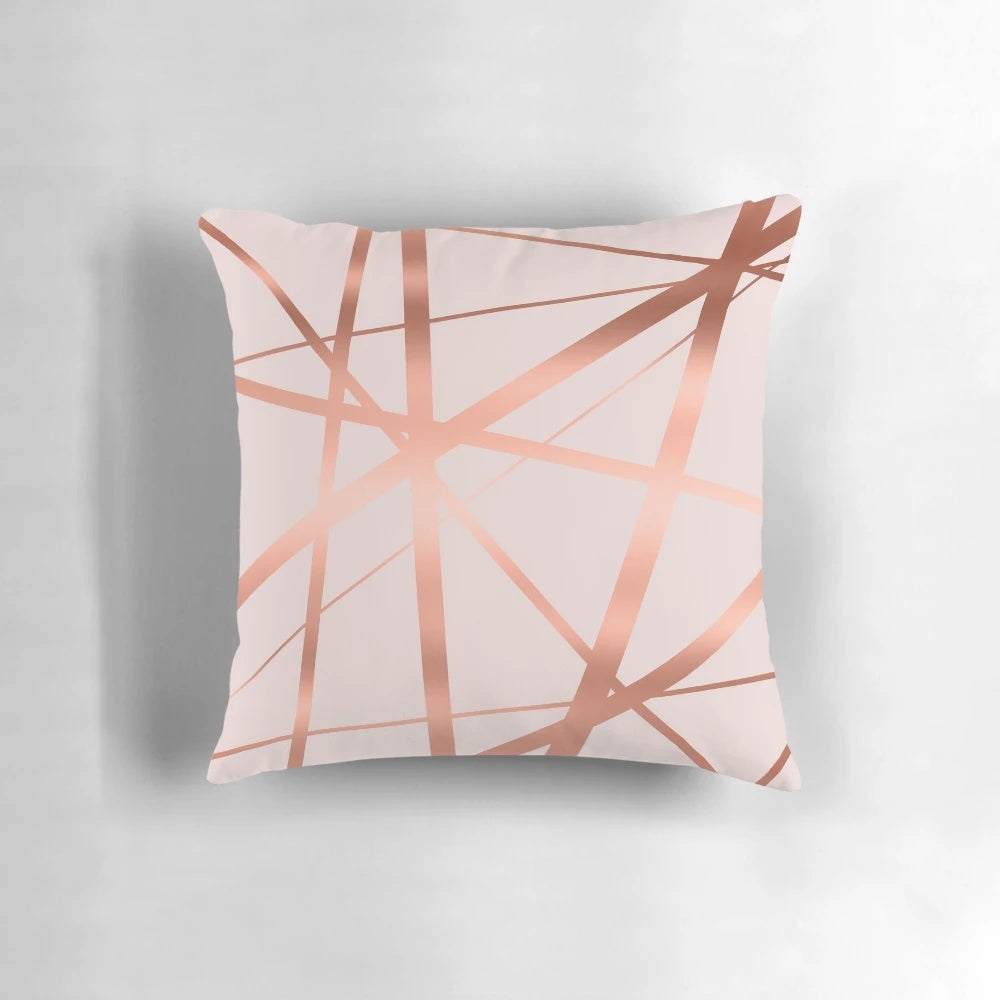 Decorative geometric pillow in a modern pink and copper color scheme