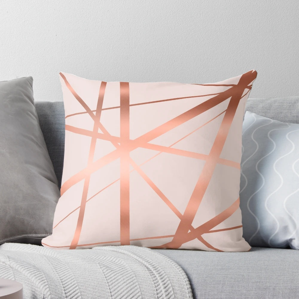 Decorative geometric pillow in a modern pink and copper color scheme