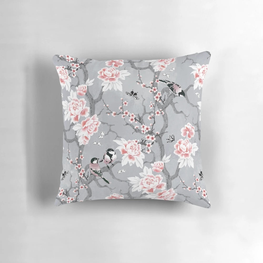 A decorative throw pillow with a beautiful grey chinoiserie bird pattern design.