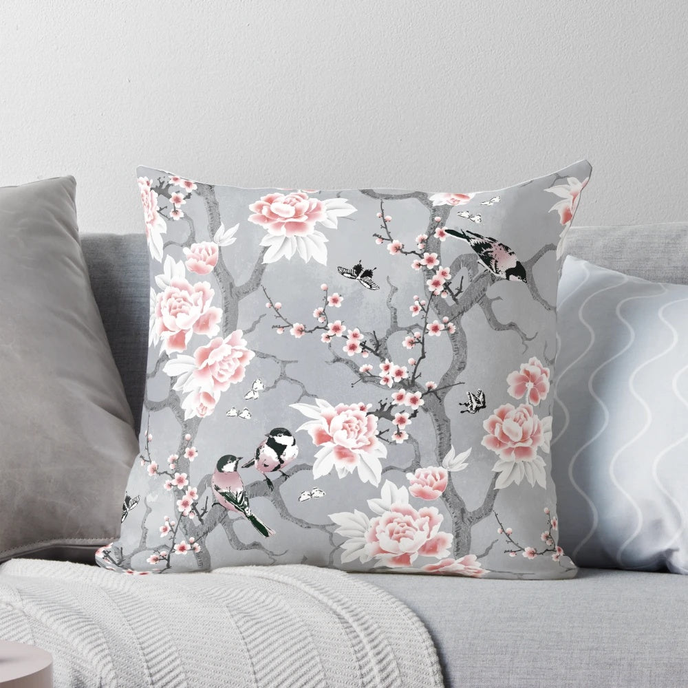 A decorative throw pillow with a beautiful grey chinoiserie bird pattern design.
