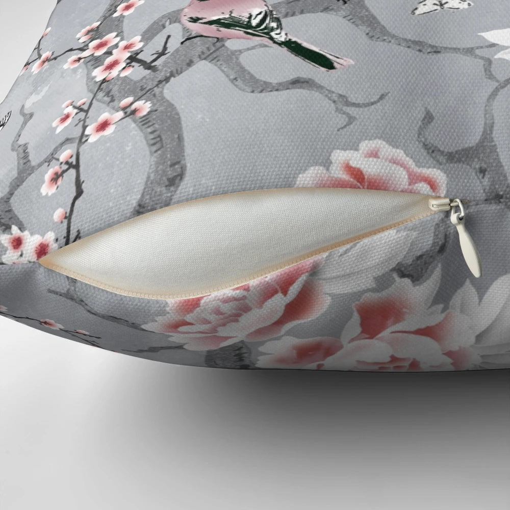 A decorative throw pillow with a beautiful grey chinoiserie bird pattern design.