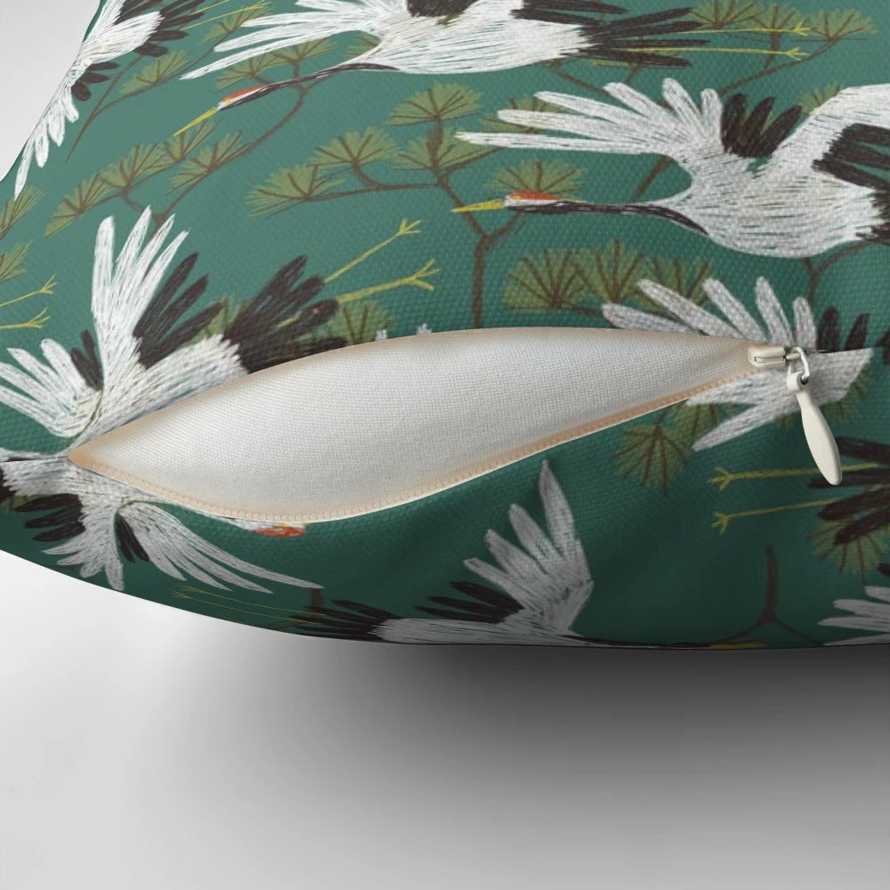A beautiful throw pillow featuring a repeating Japanese crane pattern in shades of blue, teal, and white.