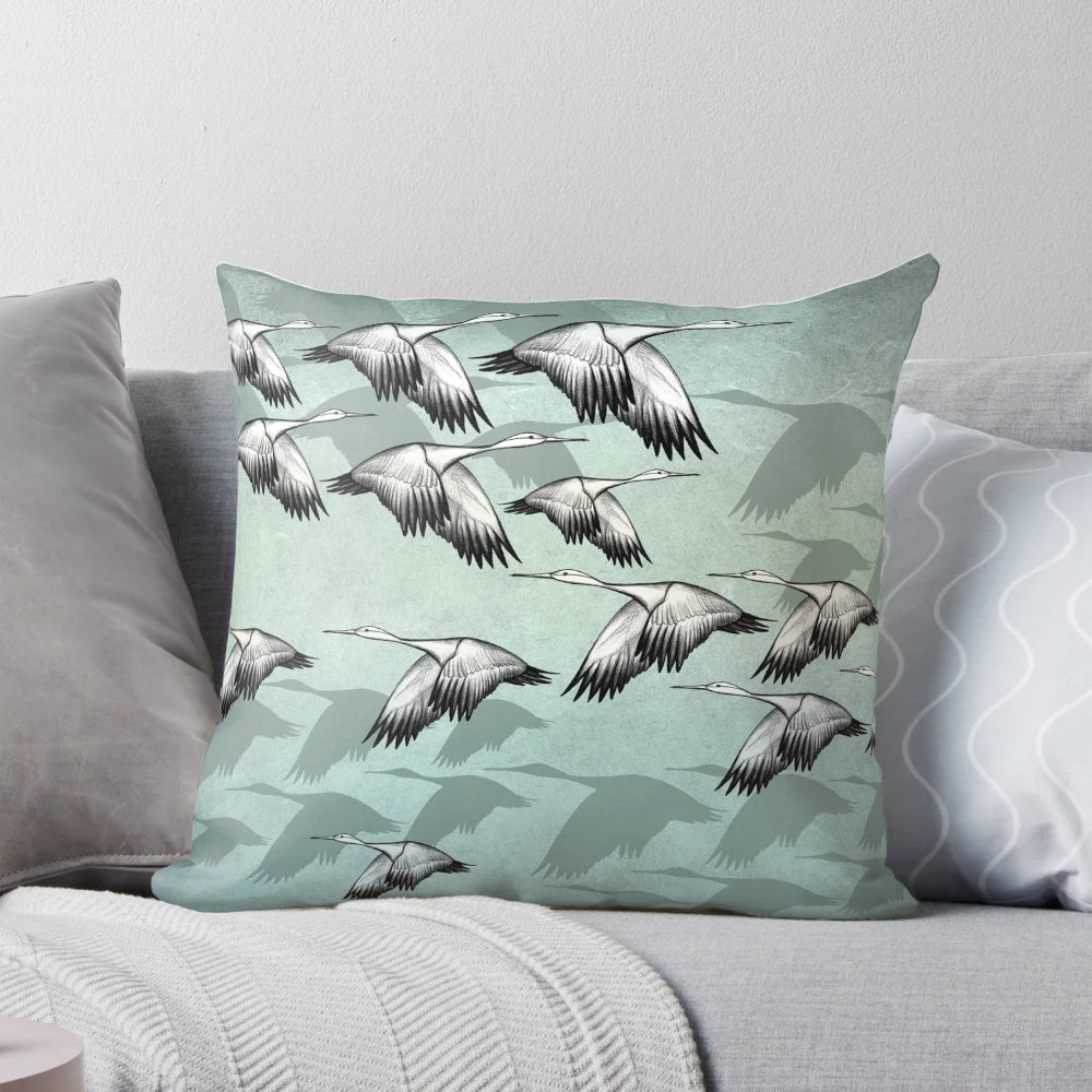 Decorative Japanese-inspired throw pillow featuring a pattern of graceful flying cranes in shades of green and earthy tones.