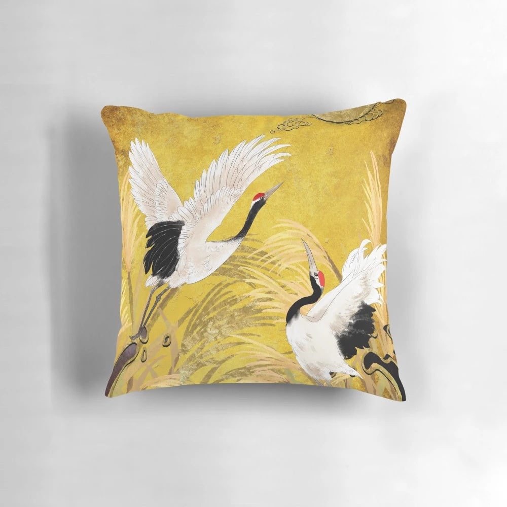 Closeup image of a traditional oriental pillow featuring a seamless pattern of golden Japanese cranes on a black background.