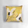 Closeup image of a traditional oriental pillow featuring a seamless pattern of golden Japanese cranes on a black background.