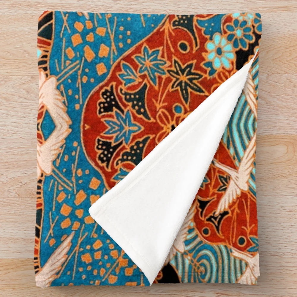 Plush blanket featuring white cranes flying over blue waters and spring flowers