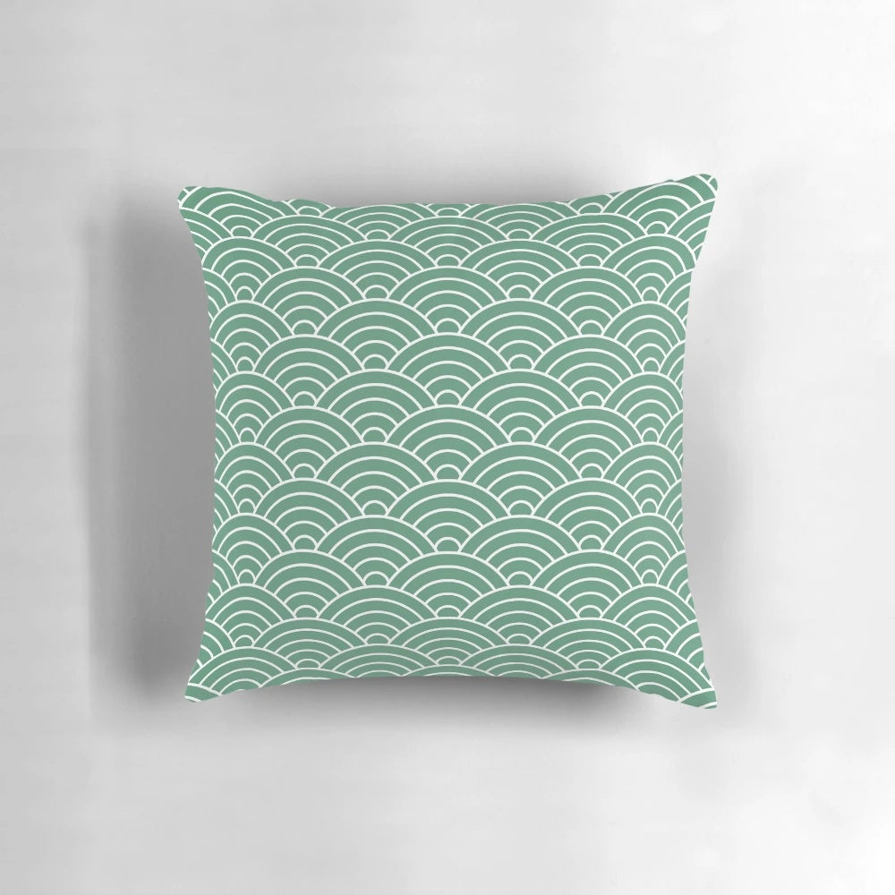 Decorative green pillow with a repeating fan pattern, inspired by Japanese design and featuring a fish scale-like motif.