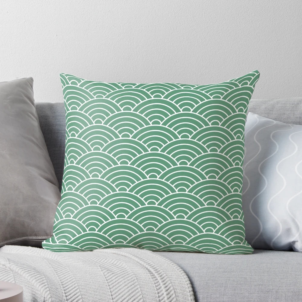 Decorative green pillow with a repeating fan pattern, inspired by Japanese design and featuring a fish scale-like motif.