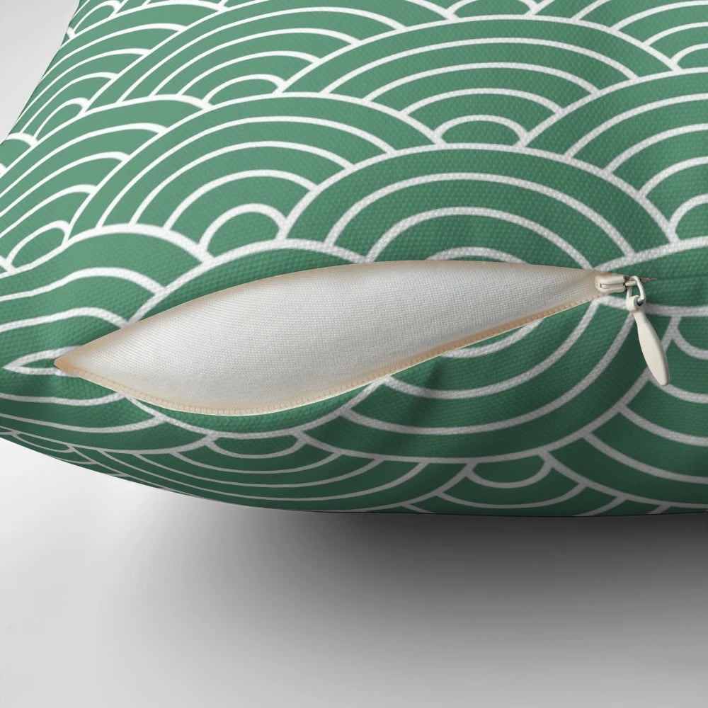Decorative green pillow with a repeating fan pattern, inspired by Japanese design and featuring a fish scale-like motif.