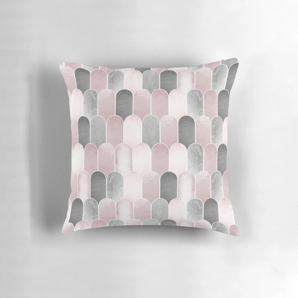 A minimalist mid century-inspired pillow featuring a pattern of overlapping arches in blush pink and grey.