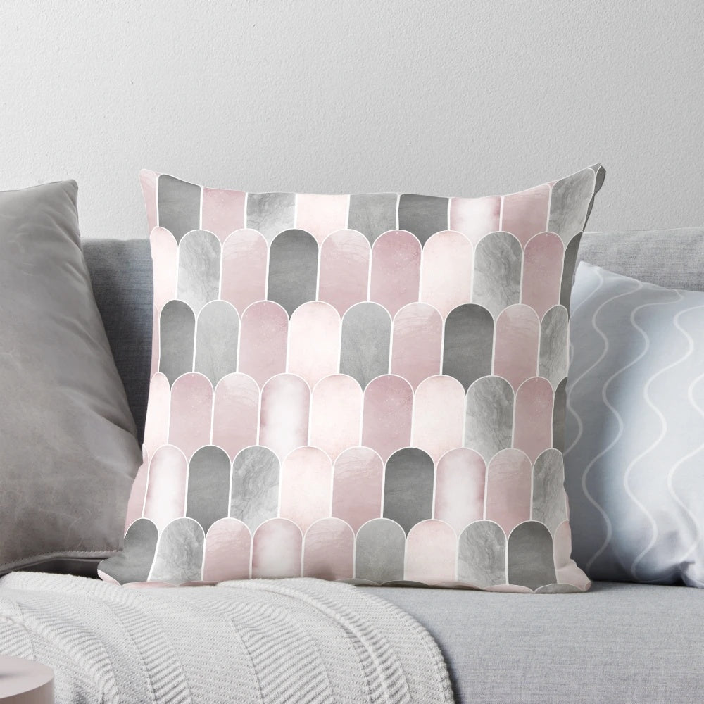 A minimalist mid century-inspired pillow featuring a pattern of overlapping arches in blush pink and grey.